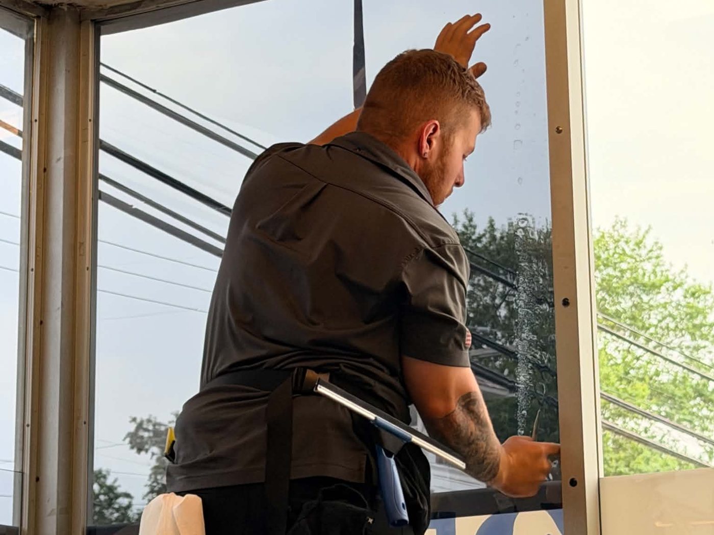Cody Becker applying window film to commercial glass