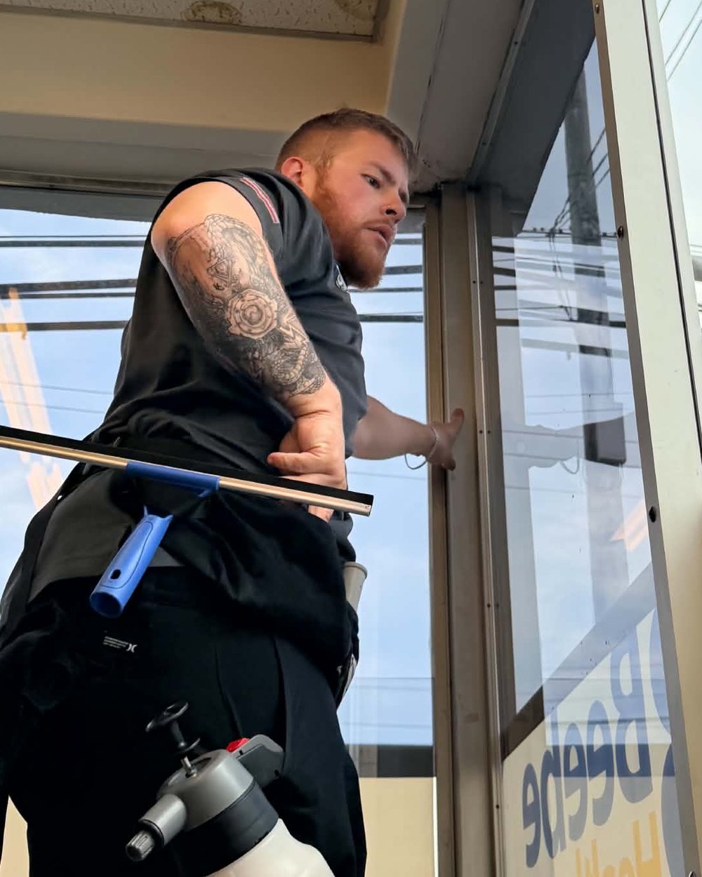 Cody Becker, founder of Second Gen Digital, installing commercial window film on a jobsite